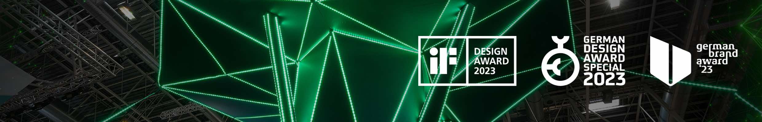 Messestand „Digitaler Wald“ für Lynqtech. Konzeption, Planung und Design, einschließlich Promotion zur e-World 2022. Auszeichnungen: iF Design Award 2023, German Design Award Special 2023, German Brand Award 2023. Bild: Froschperspektive einer abstrakten, baumartigen Installation auf einer Messe, deren geometrische Äste durch leuchtend grüne LED-Streifen in einer dunklen Umgebung hervorgehoben werden.